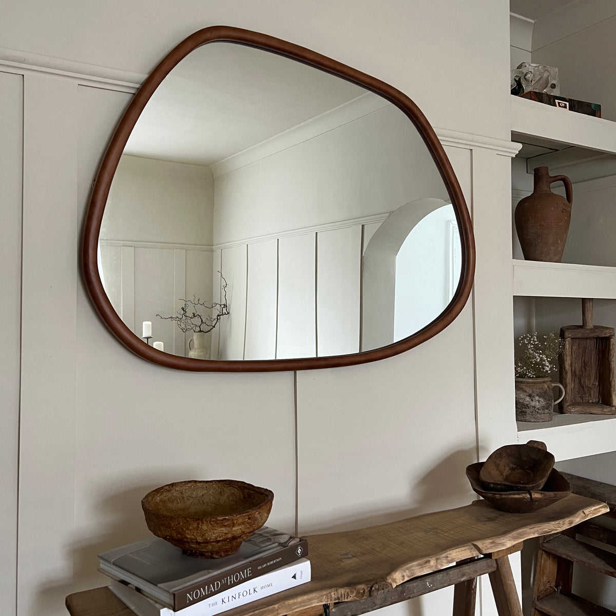 Organic irregular walnut-coloured wooden wall mirror displayed horizontally