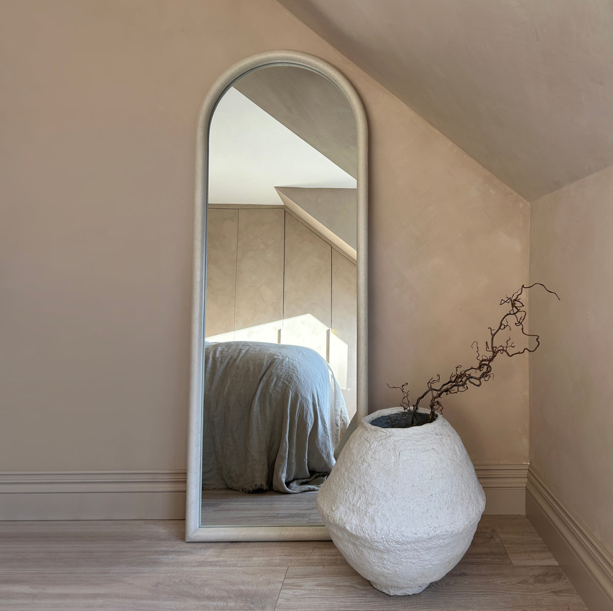 Large arched concrete mirror leaning against wall