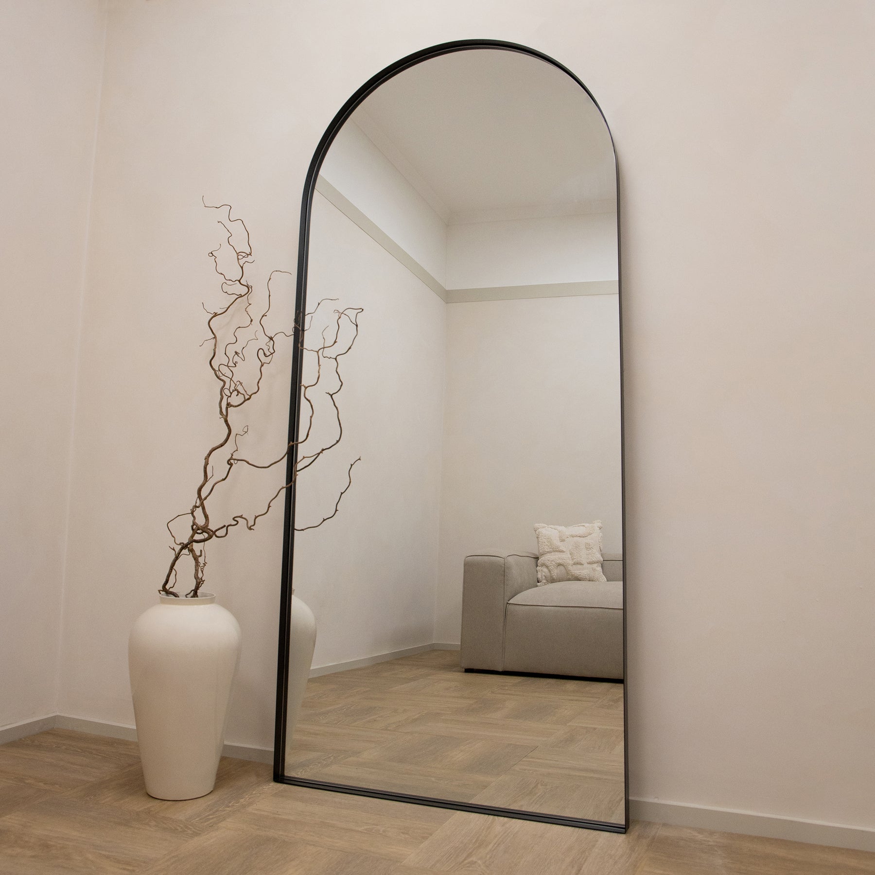 Full length arched black XXL metal mirror leaning against wall
