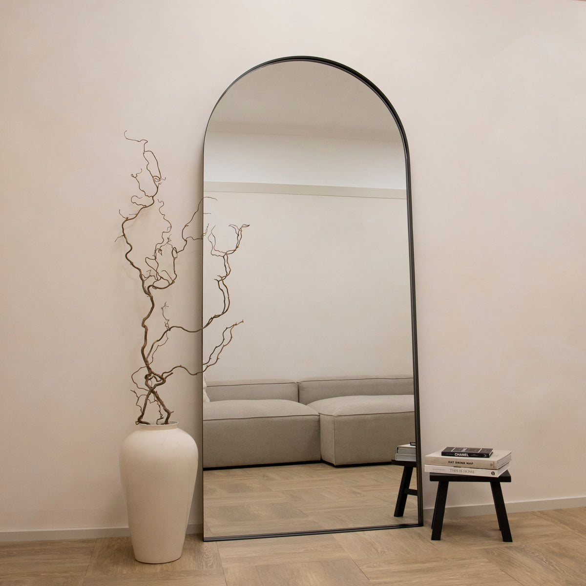 Full length arched black extra large metal mirror leaning against wall