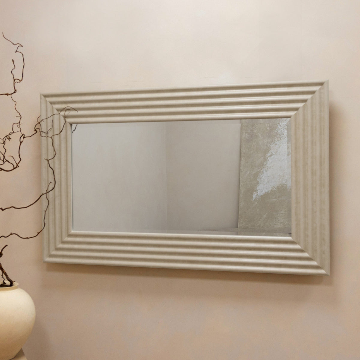 Large ribbed concrete console mirror displayed on wall