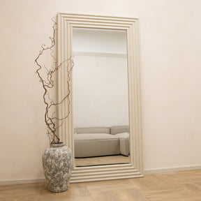 Full length ribbed concrete mirror leaning against wall