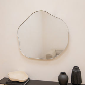 Ecru metal pond shaped irregular wall mirror displayed on wall