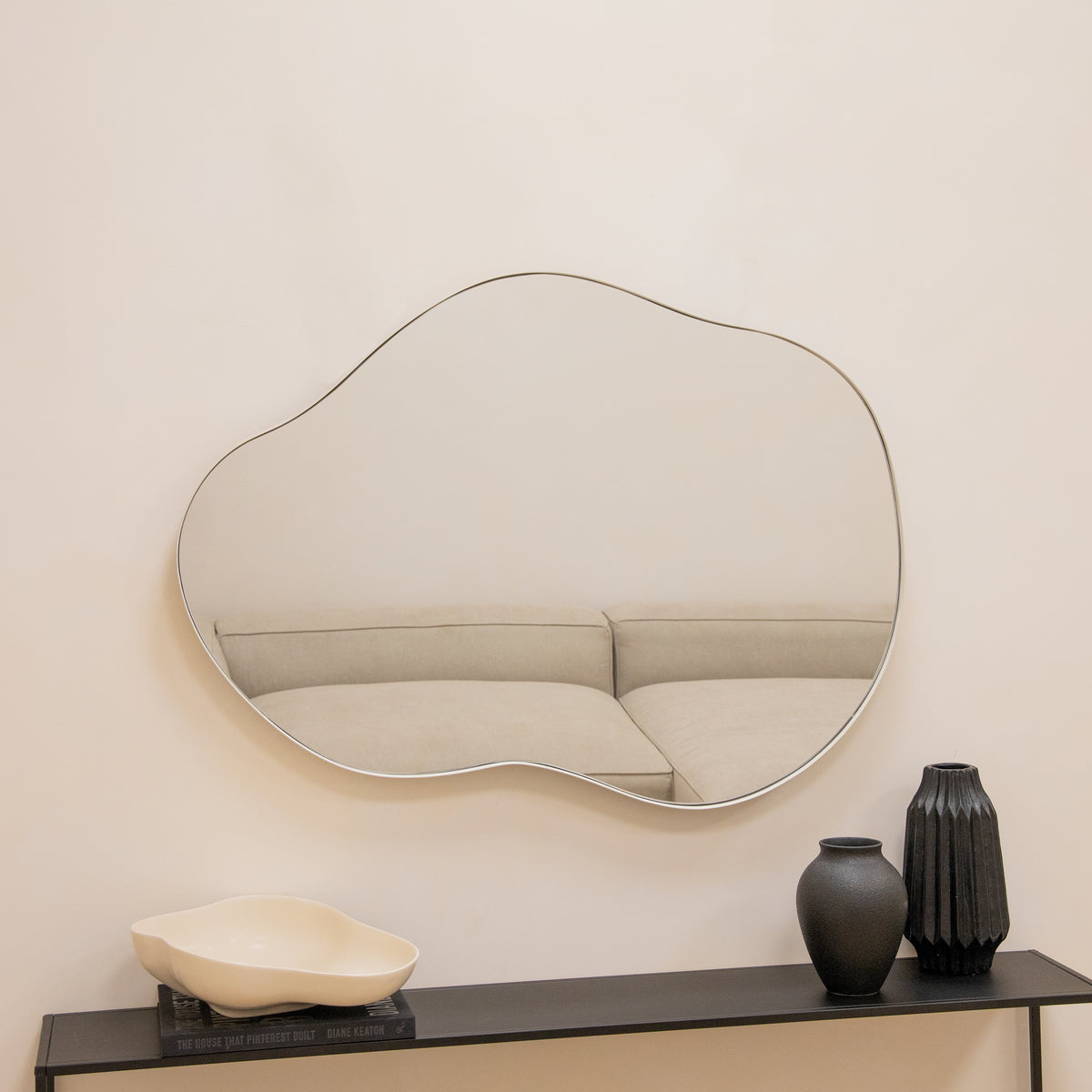 Ecru metal pond shaped irregular wall mirror displayed horizontally on wall