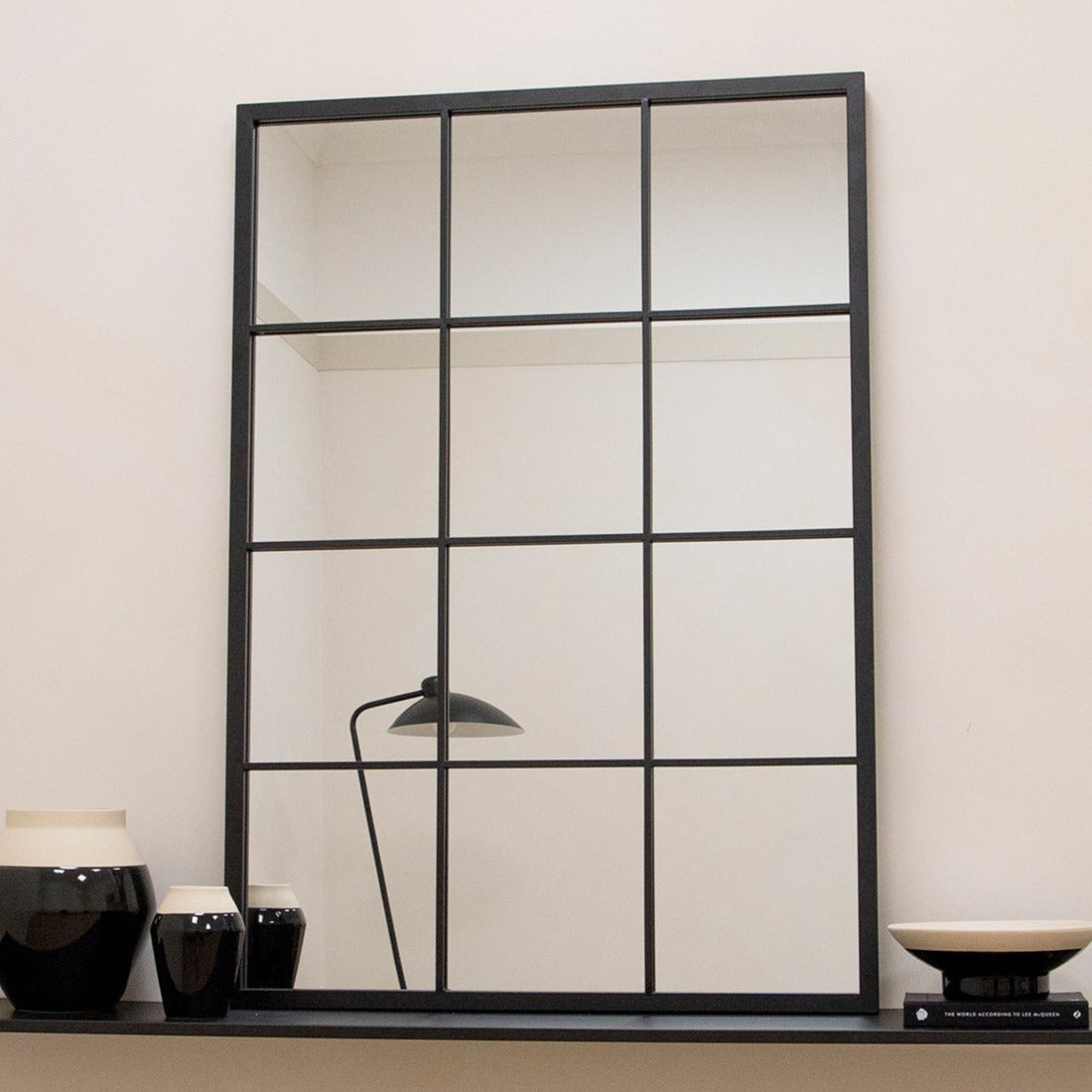 Large black industrial metal window mirror displayed on table