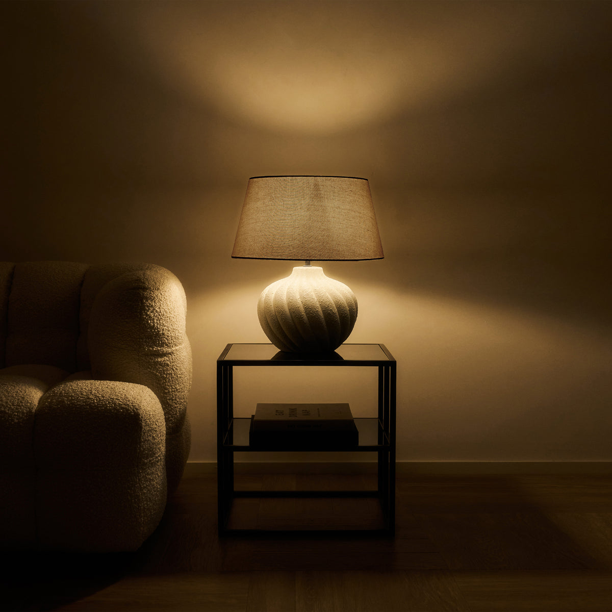 Textured ceramic based table lamp beige shade emitting warm lighting