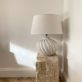 Textured ceramic based table lamp natural shade on organic pedestal
