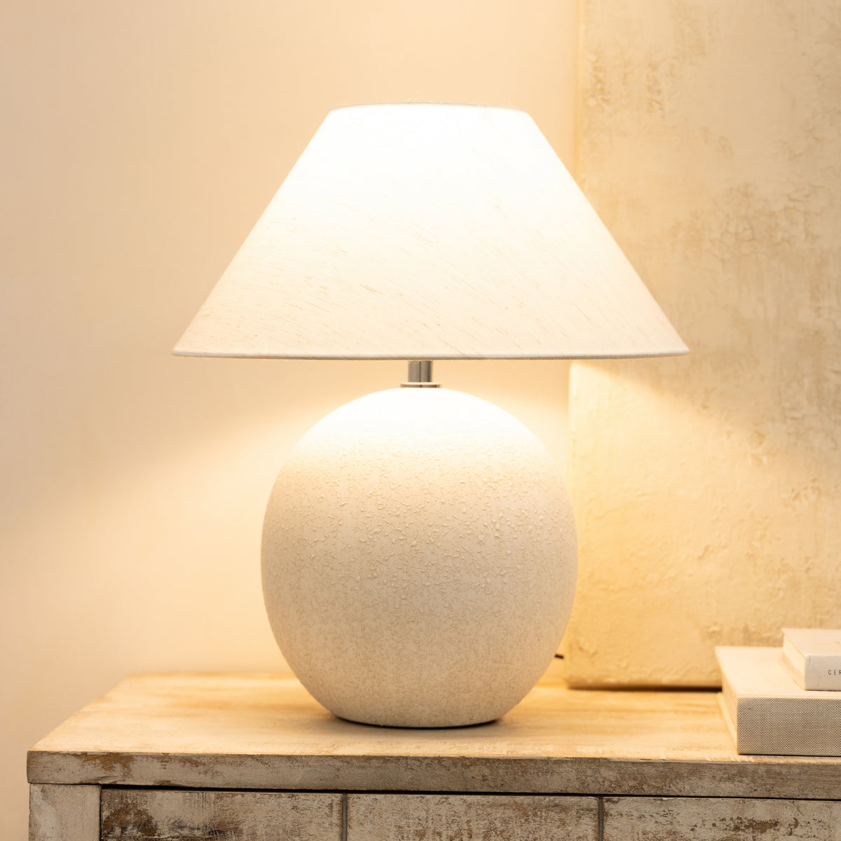Stone ceramic coolie shade table lamp emitting warm light