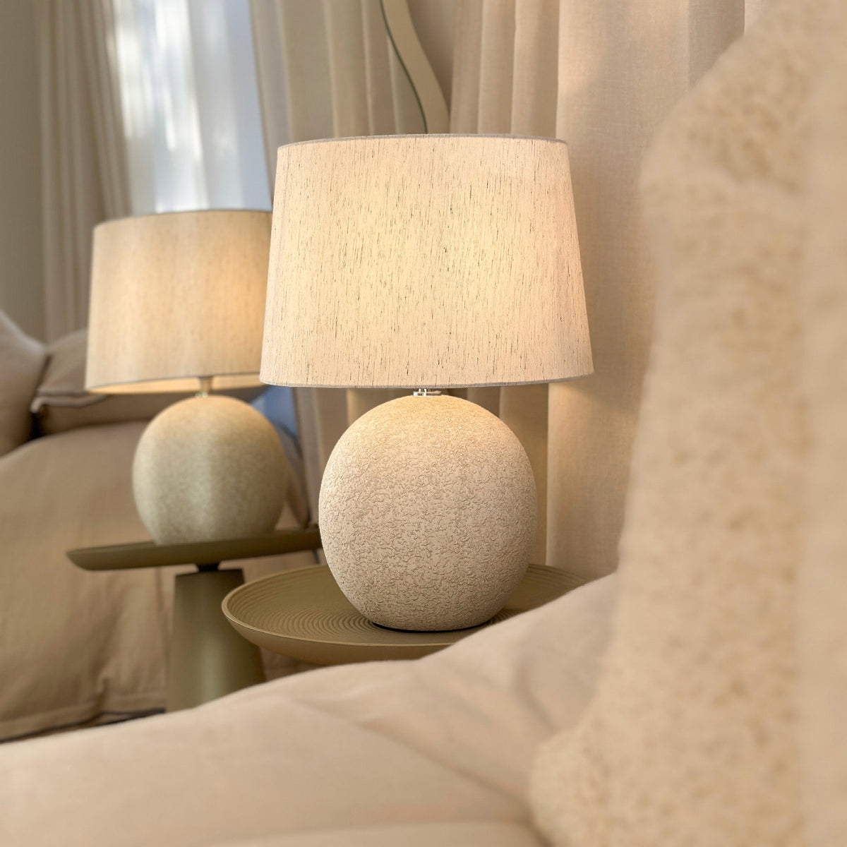 Stone ceramic drum shade table lamp on bedside table