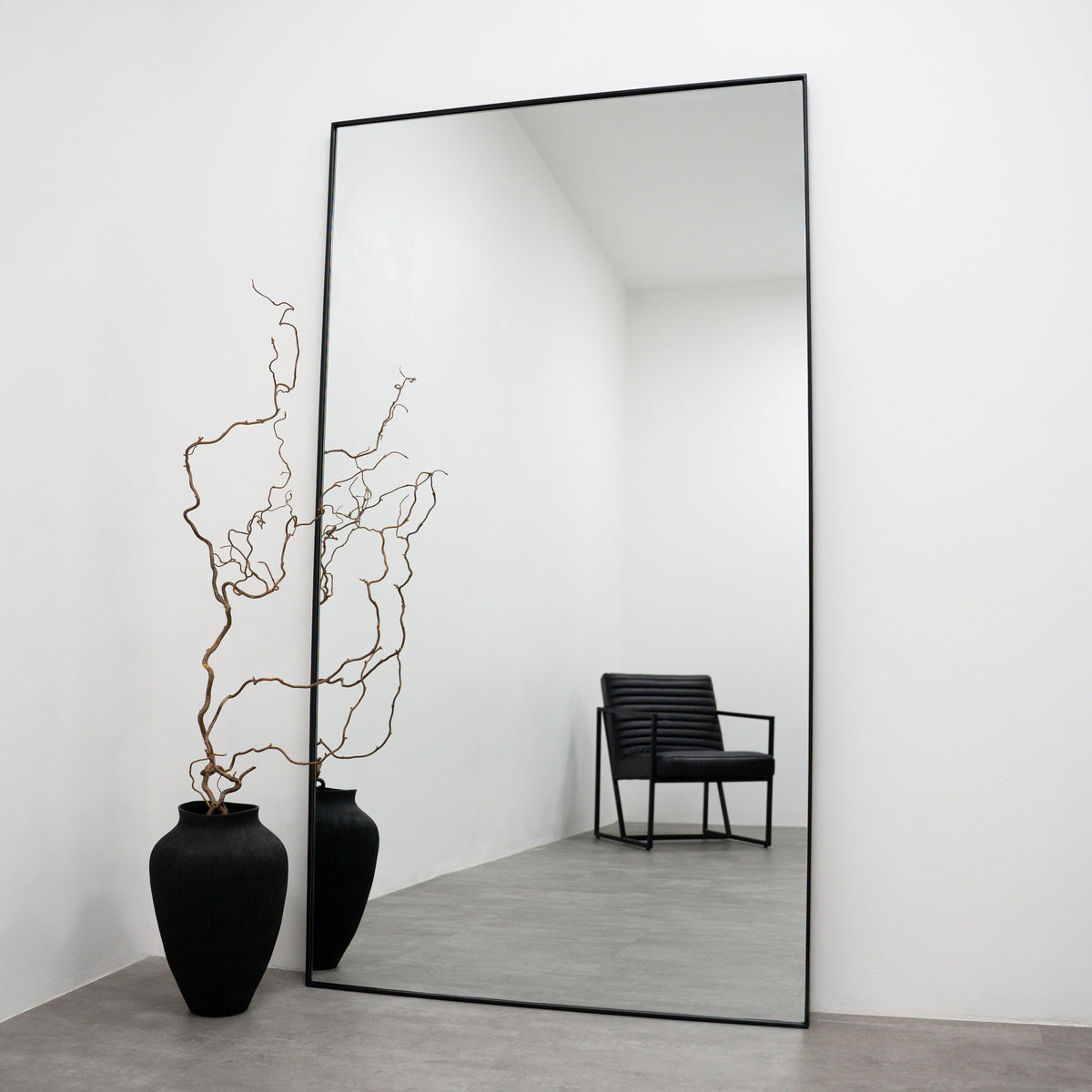 Full Length Black Curved Metal Extra Large Mirror next to vase