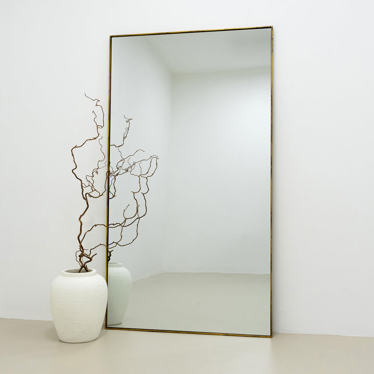 Full Length Gold Extra Large Metal Mirror beside vase