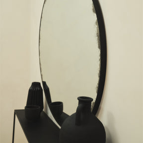 Black Large Antique Glass Round Metal Mirror detail shot of mirror amongst vases