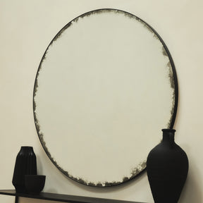 Black Large Antique Glass Round Metal Mirror on wall beside ceramics