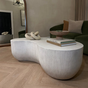 Minimal Concrete Shaped Coffee Table Large in living room, adorned with books and organic shapes