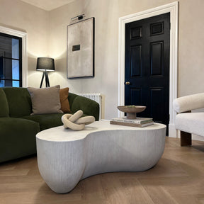 Minimal Concrete Shaped Coffee Table Large displayed beside green sofa