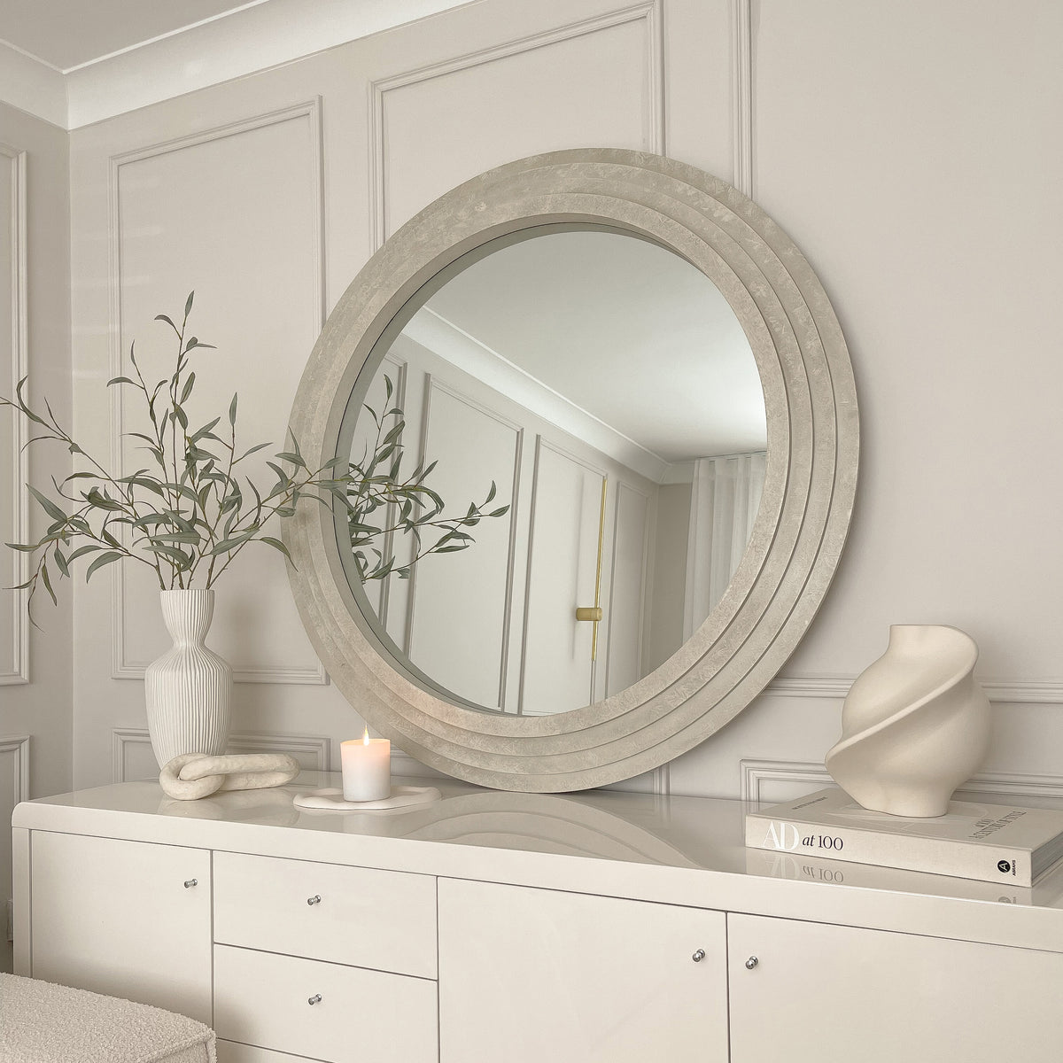 Round Concrete Wall Mirror displayed as a lean to atop a console table