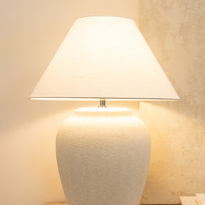 Detail shot of Stone Ceramic Coolie Shade Table Lamp emitting warm lighting