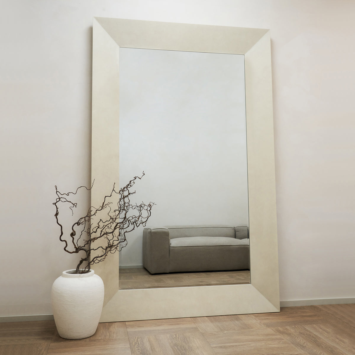 Full length extra large rectangular concrete mirror beside vase