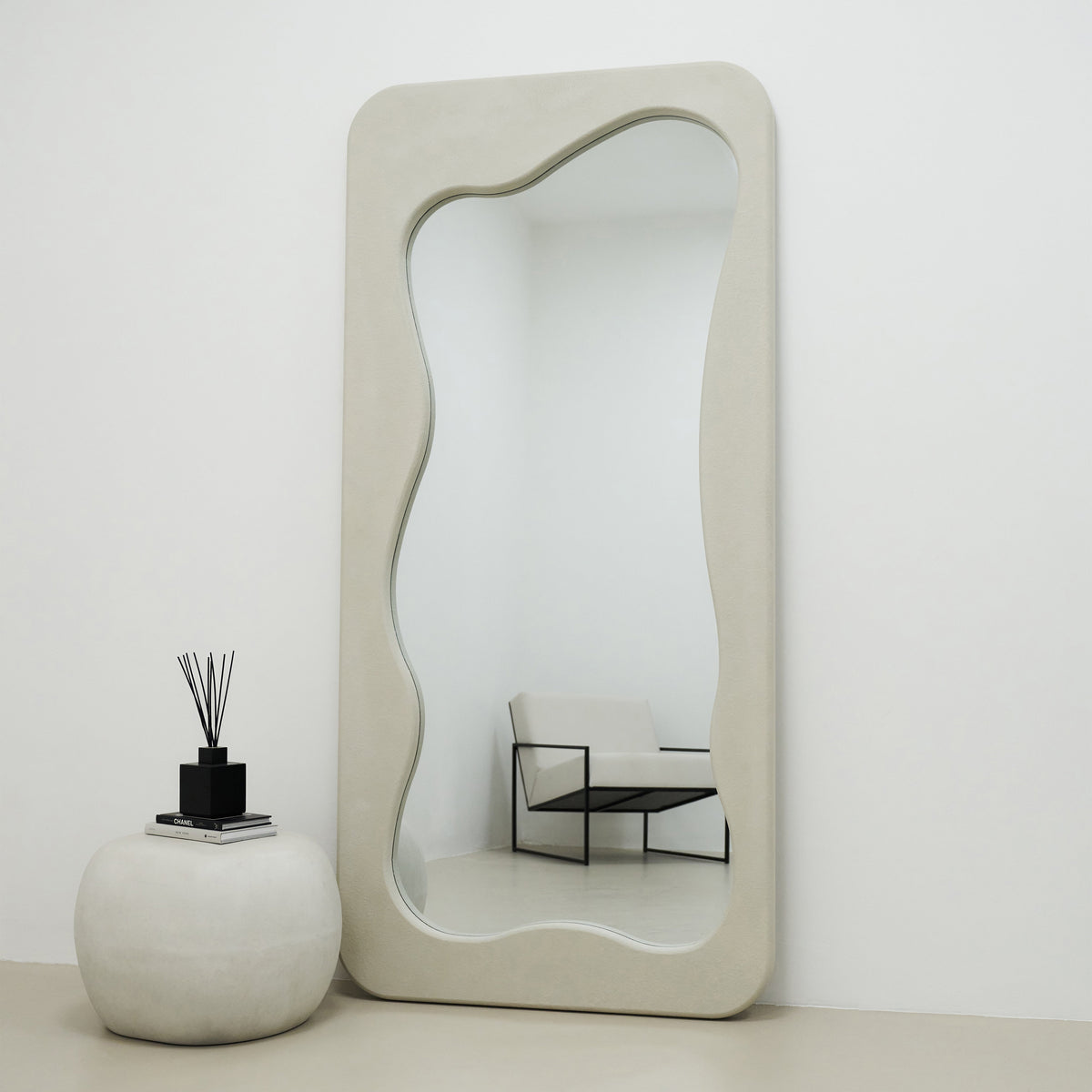 Full Length Irregular Concrete Mirror standing tall beside table