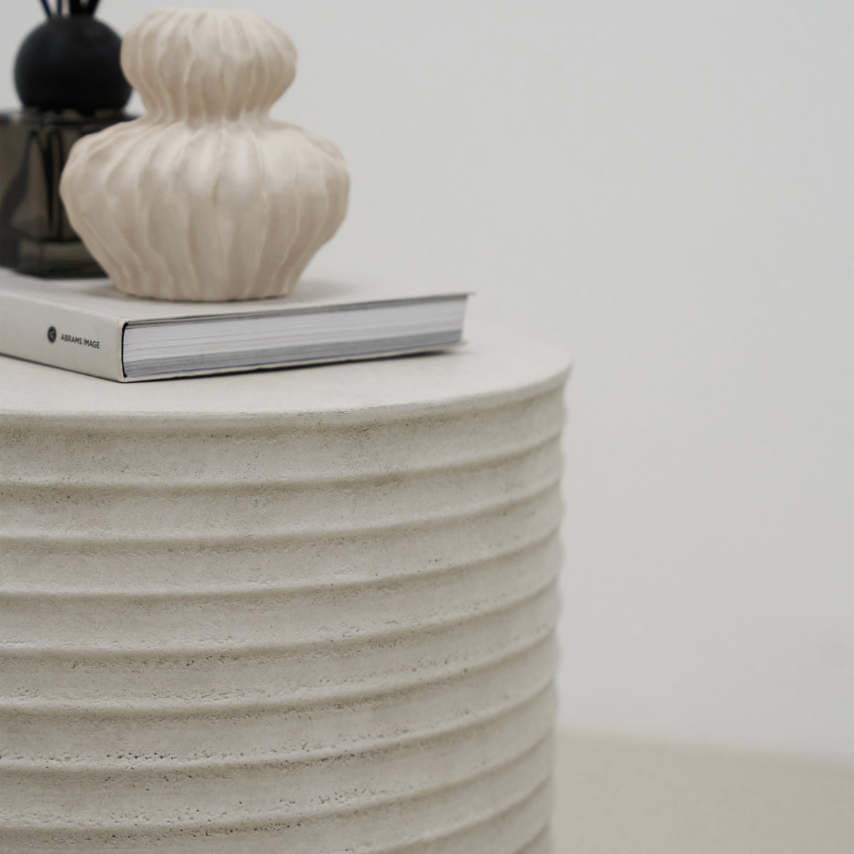 Minimal Concrete Ribbed Side Table adorned with ceramics