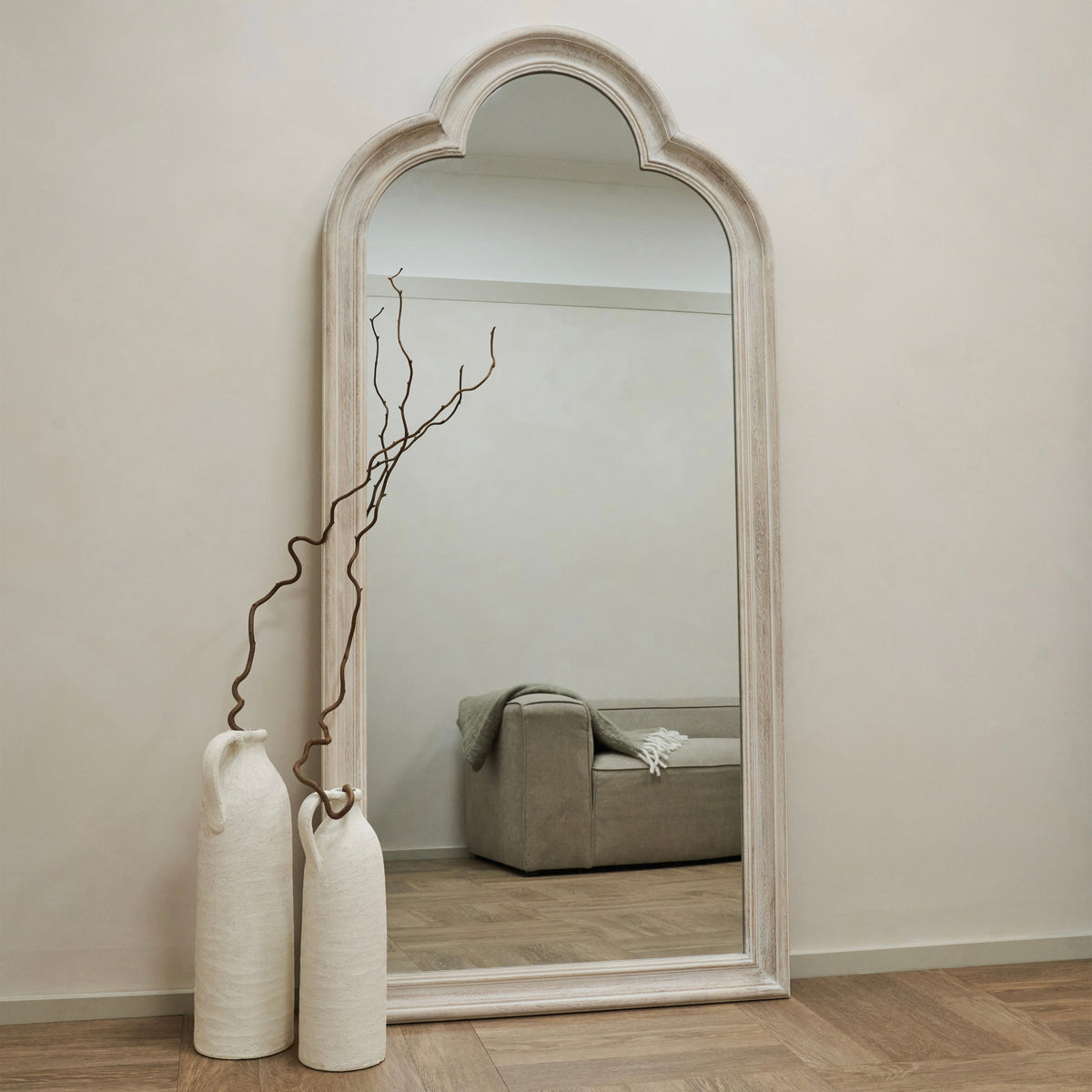 White Washed Wood Arched Full Length Mirror reflecting sofa