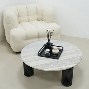 Travertine round large coffee table adjacent to chair