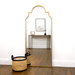 Gold industrial arched metal extra large mirror leaning against wall