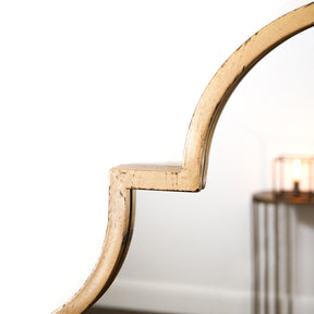 Closeup of gold industrial arched metal large mirror