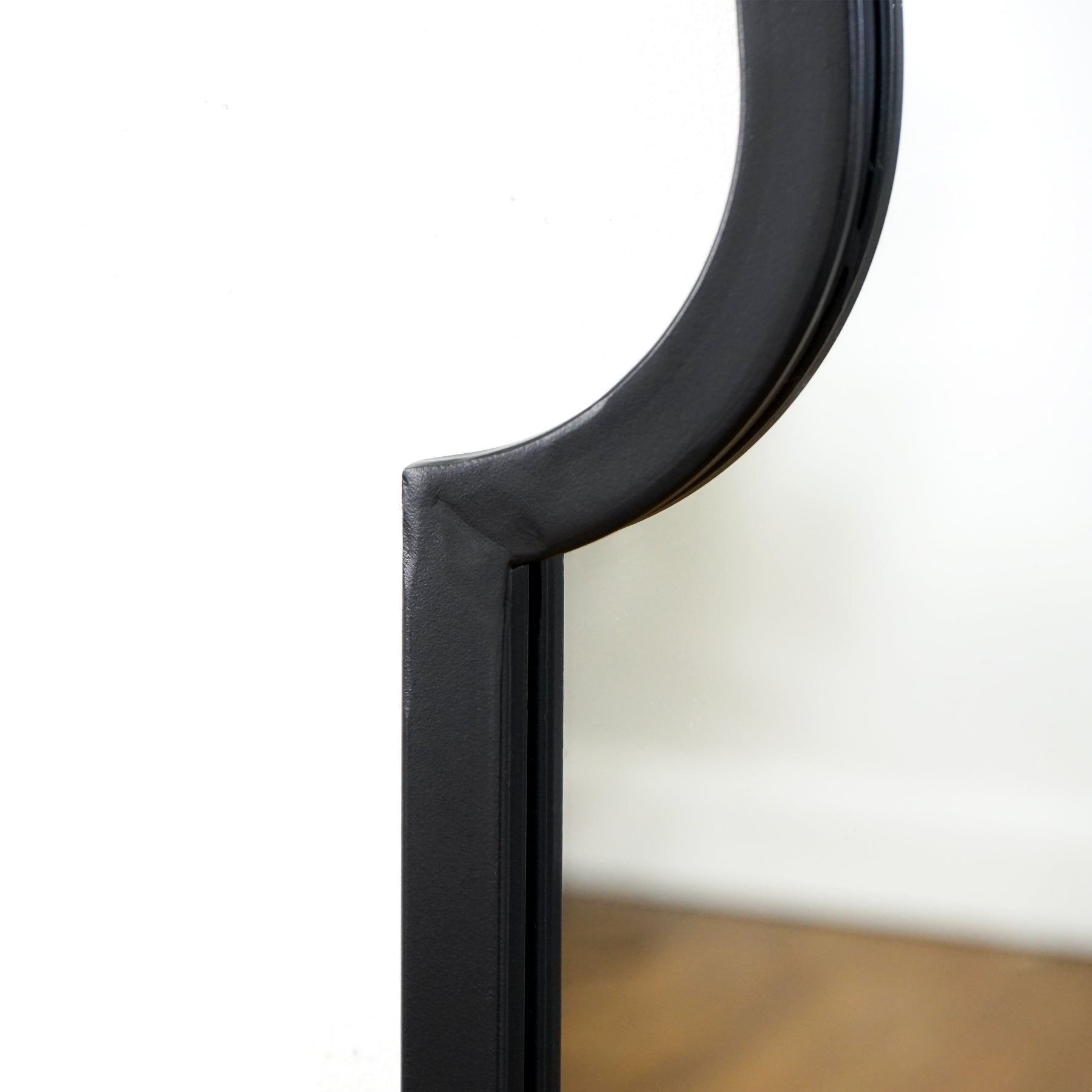 Closeup of Black industrial arched metal large mirror