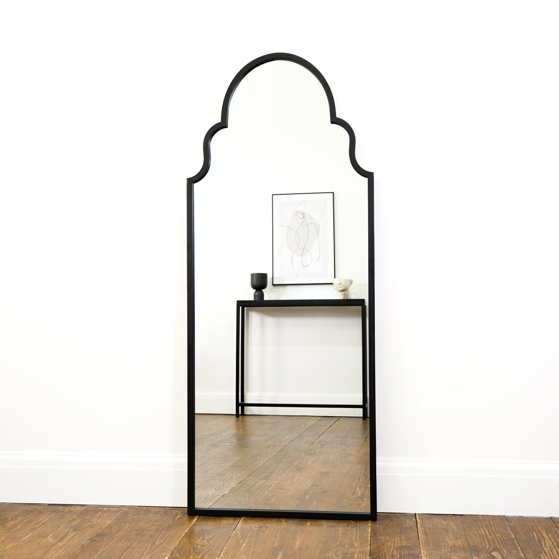 Black industrial arched metal extra large mirror leaning against wall