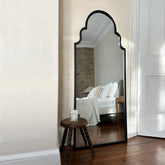 Black industrial arched metal extra large mirror leaning against wall