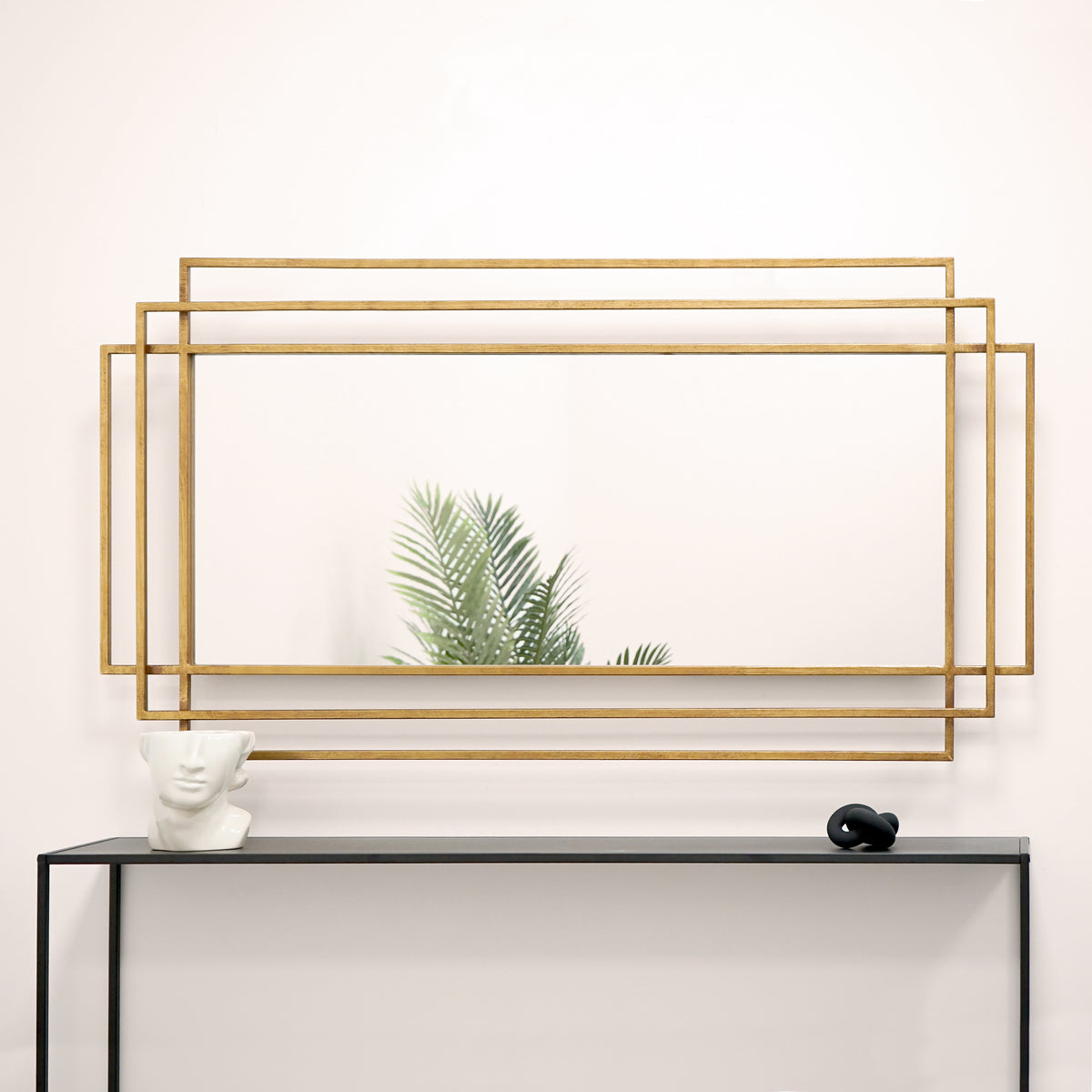 Large gold rectangular metal mirror displayed on wall