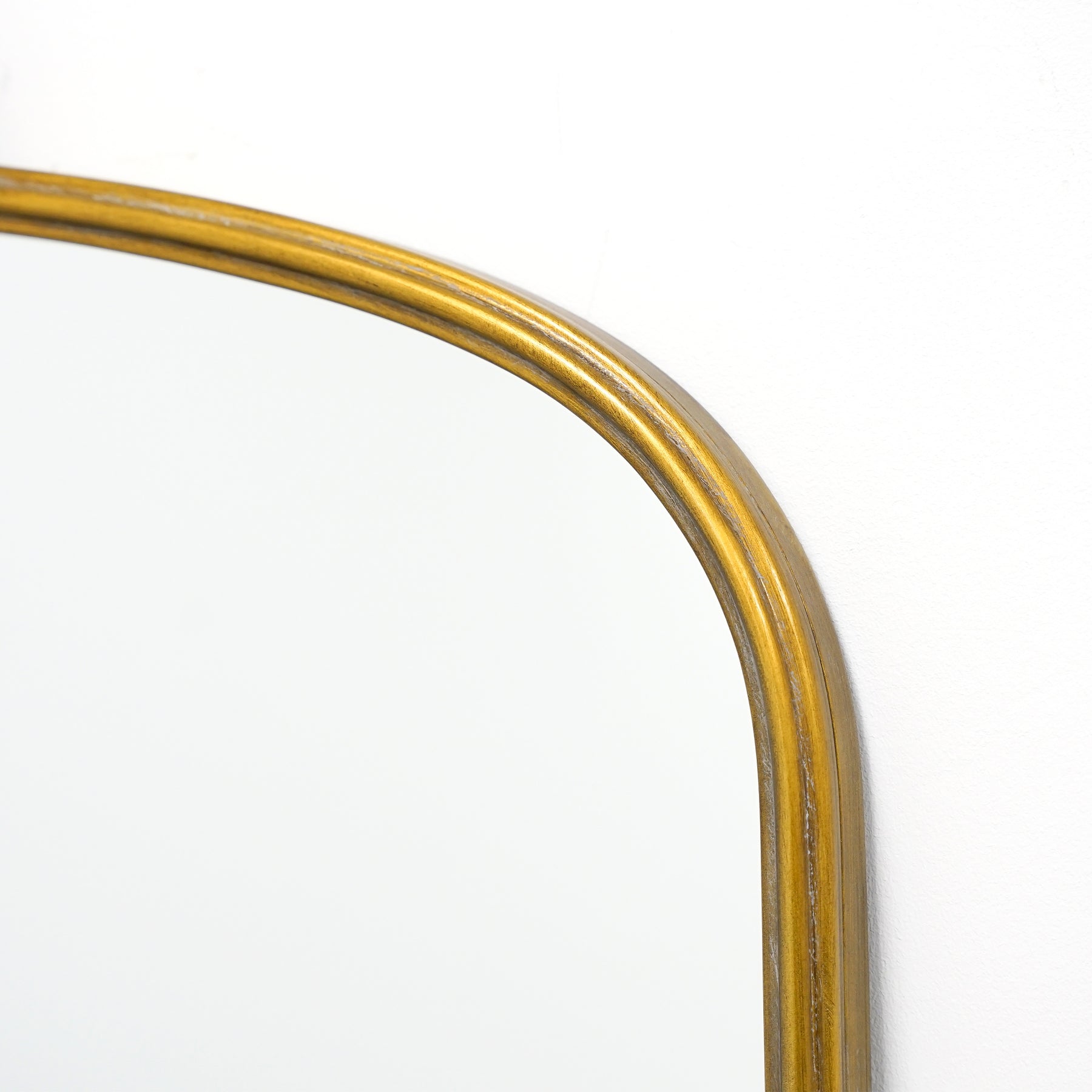 Closeup of Gold arched vintage metal overmantle mirror