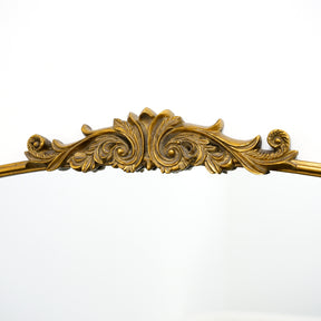 Closeup of extra large gold ornate arched metal mirror