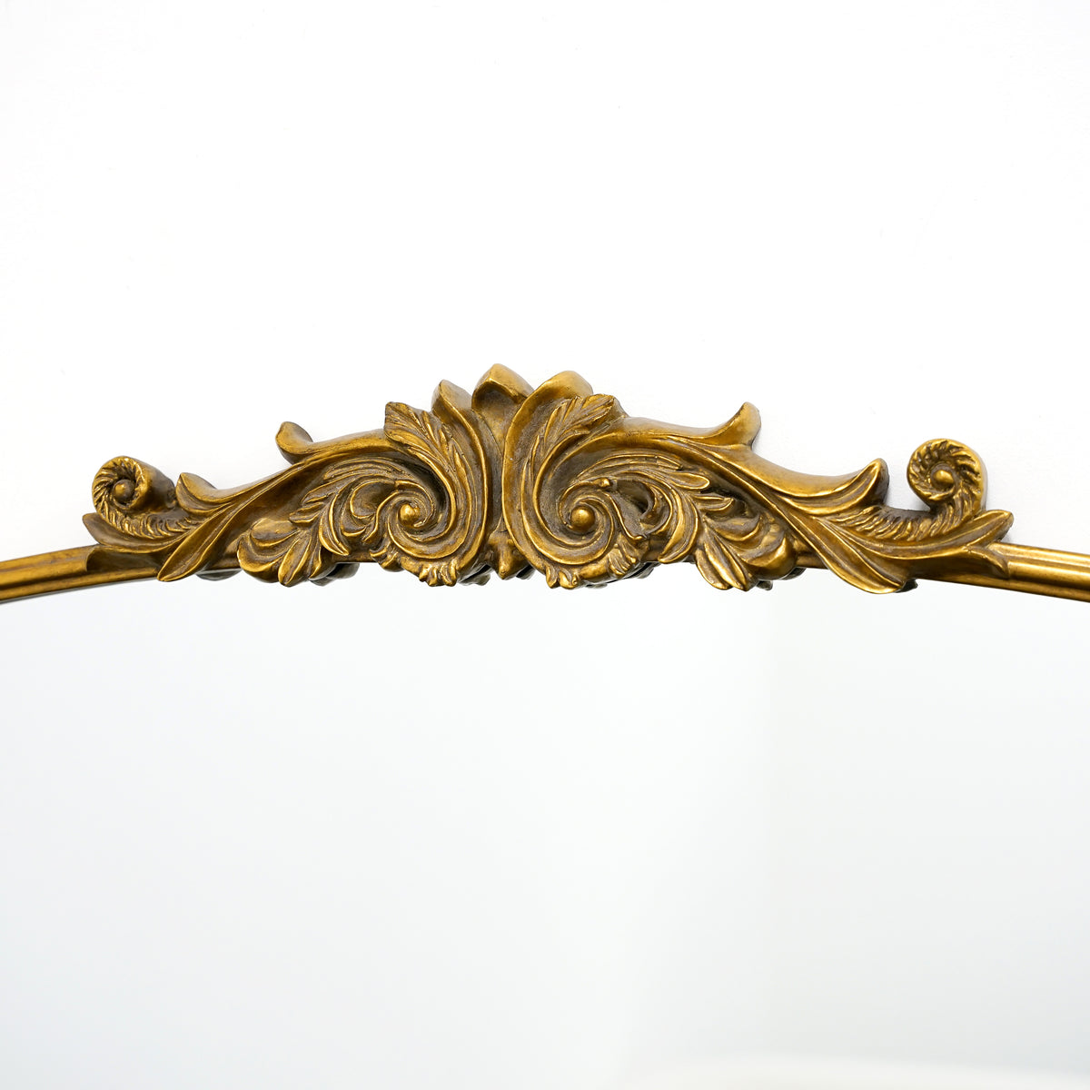 Closeup of Gold arched ornate metal overmantle mirror