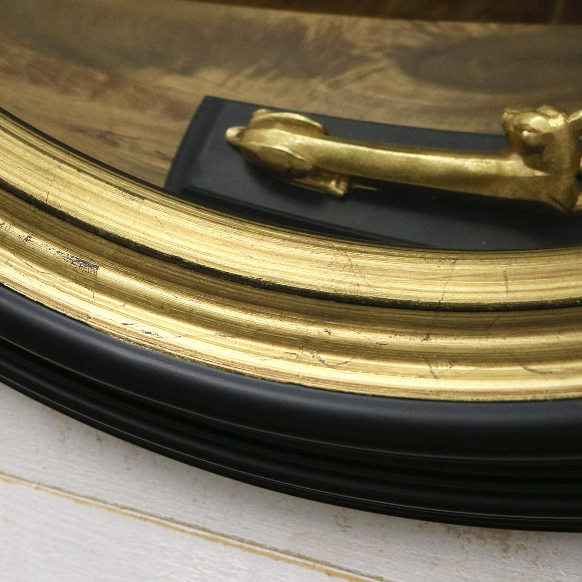 Black and gold porthole fish eye round mirror detail shot of 2 layered frame
