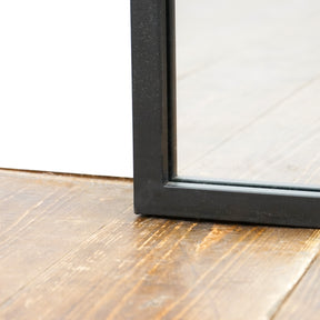 Detail shot of Full length large black metal window mirror corner