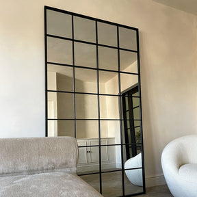 Full length XL black industrial metal window mirror leaning against wall