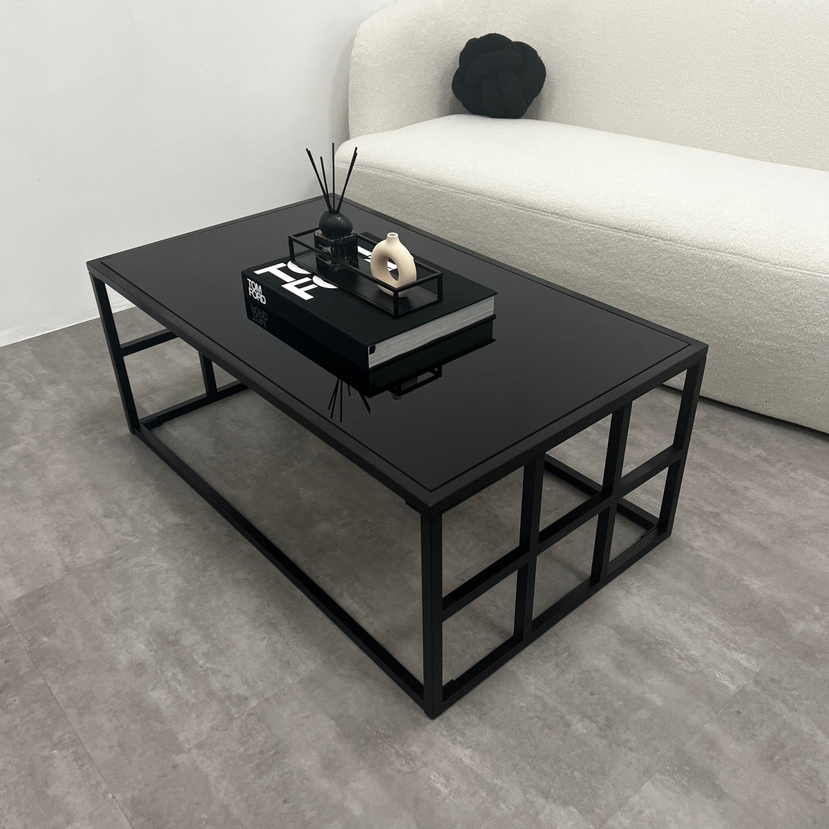 Black modern large rectangle tinted mirrored coffee table next to sofa