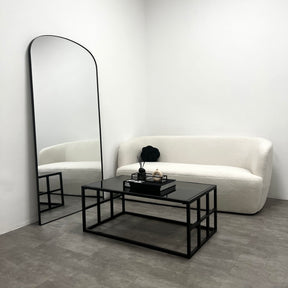 Black modern large rectangle tinted mirrored coffee table beside full length mirror