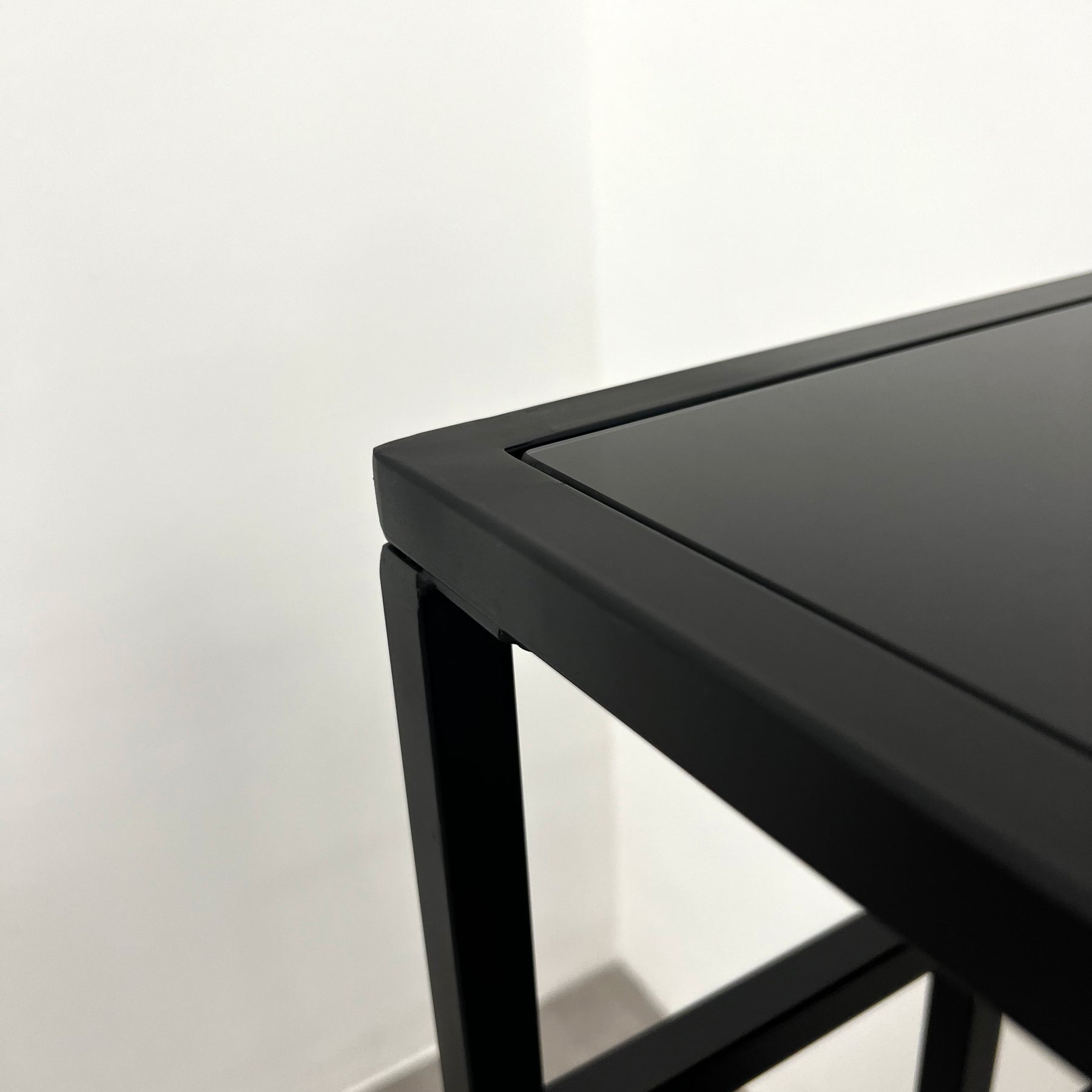 Detail shot of Black modern large rectangle tinted mirrored console table corner
