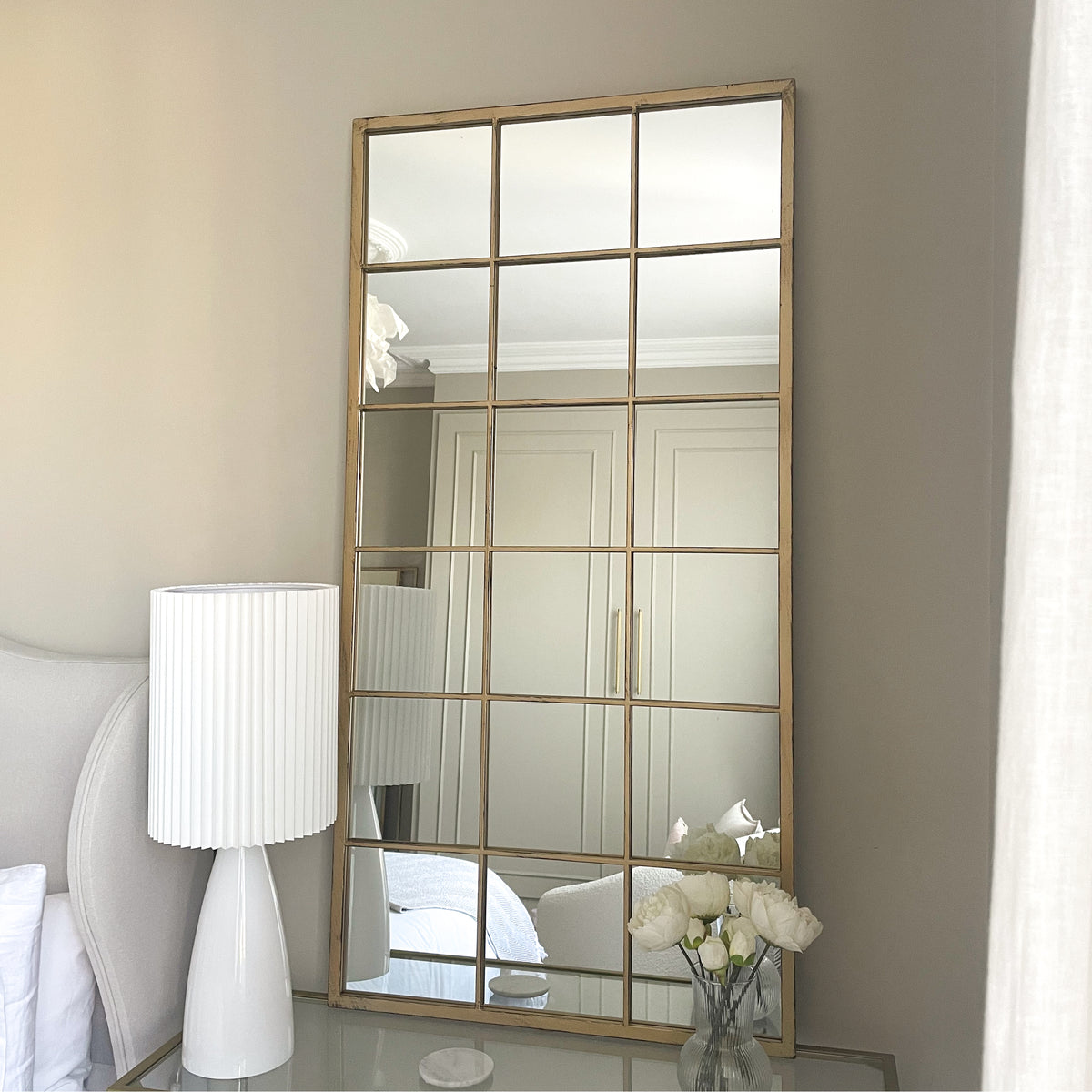 Large gold industrial metal window mirror leaning against wall
