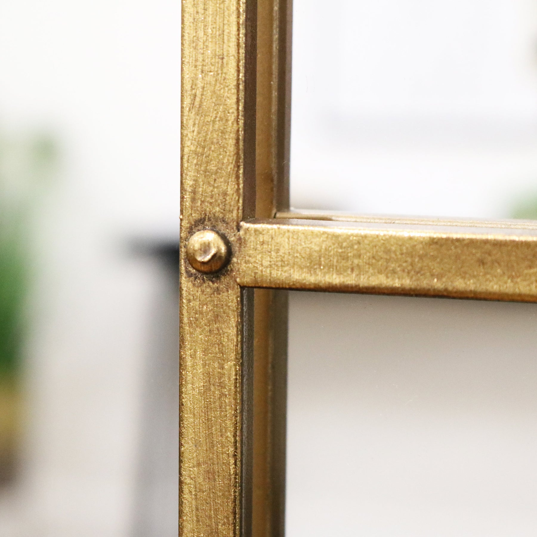 Gold industrial arched full length metal mirror closeup of frame bolt