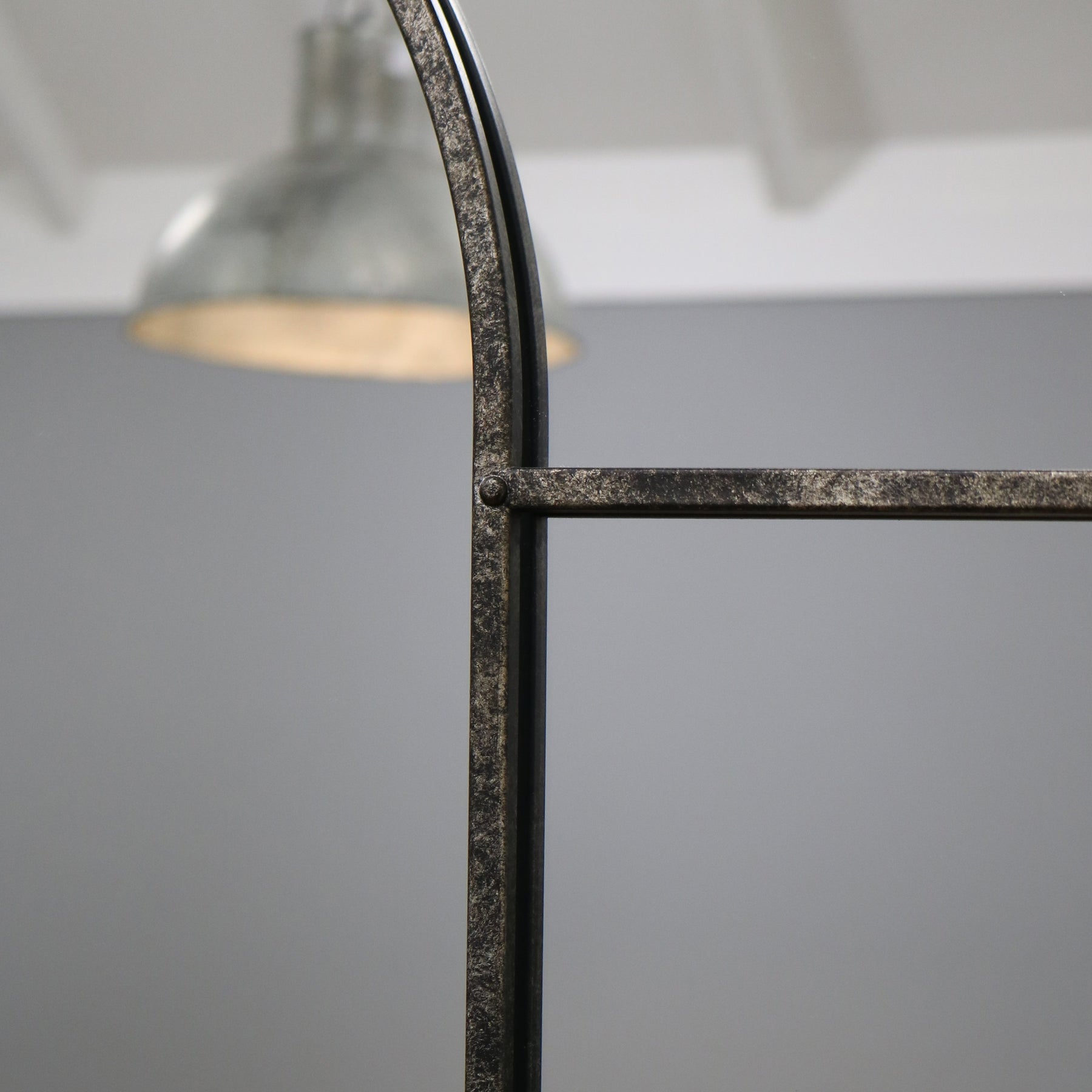 Crushed black industrial arched metal wall mirror closeup of industrial frame design