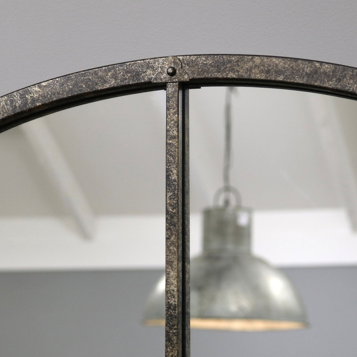 Crushed black industrial arched metal wall mirror closeup of arch