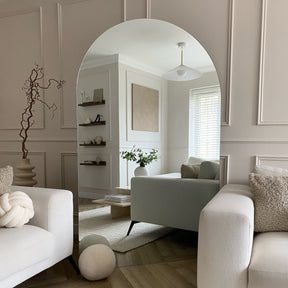 Extra large frameless arched full length mirror beside sofa