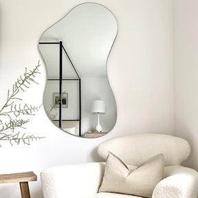 Medium Frameless Pond Mirror above chair in living room