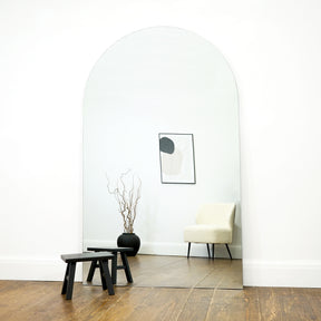 Extra large frameless arched full length mirror by stool