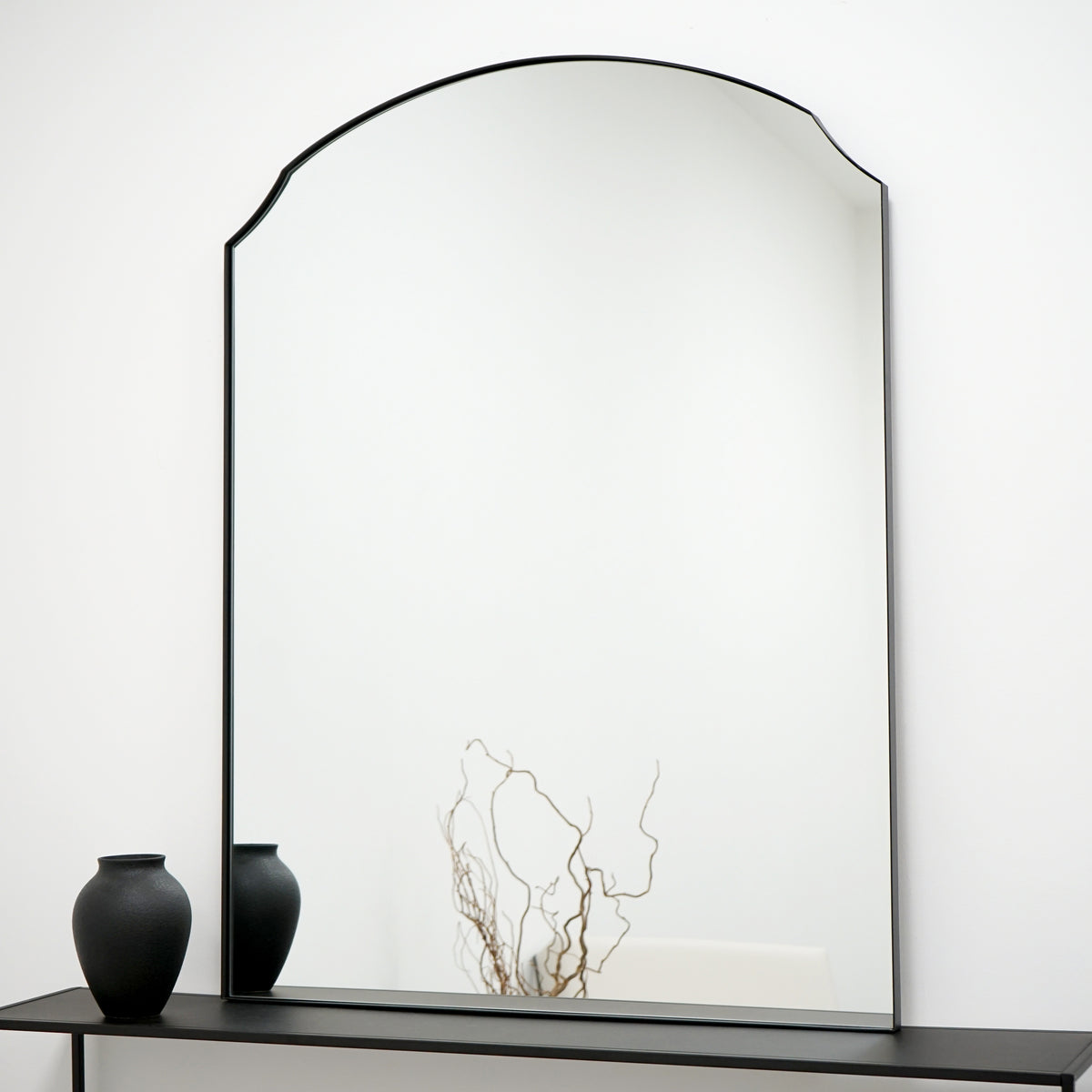 Black Arched Metal Overmantle Wall Mirror on console table