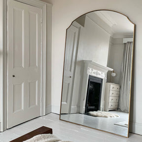 Gold Full Length Arched Metal Mirror leaning against wall in living room